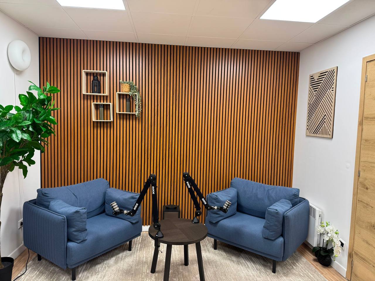 Décor Salon Bois : mur en lattes de bois et deux fauteuils bleus